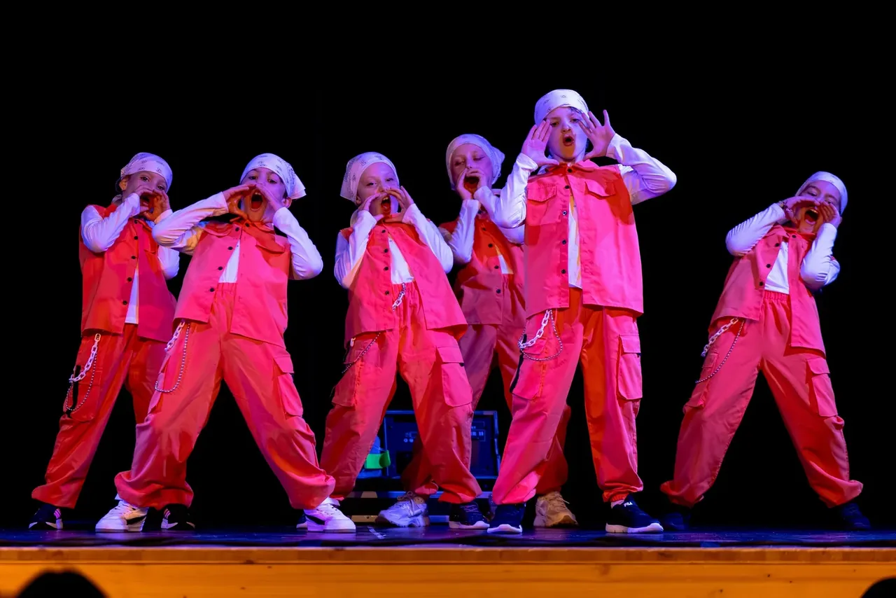 Groupe 1000 ARTS sur scène en tenue rose corail — rejoins-nous